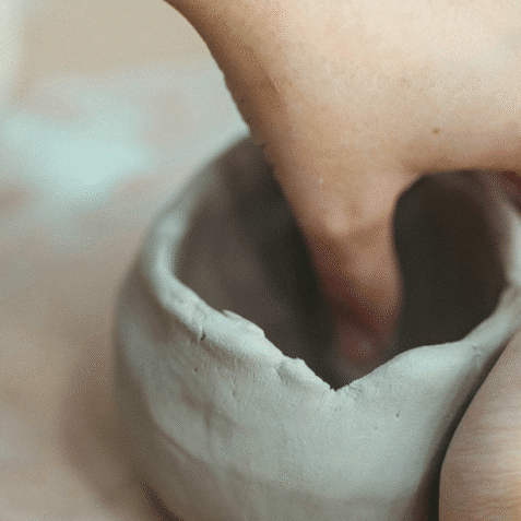 hands forming clay pot